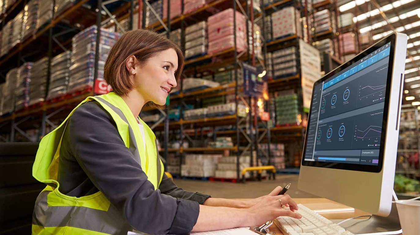 Lavoratore che guarda uno schermo in un magazzino